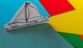 A simple ship drawn on paper stands on a multi-colored cardboard