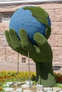 Simple still-life photo of grass hand and globe of Earth