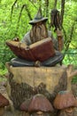 Simple still-life photo of wooden wizard with book in the forest Royalty Free Stock Photo