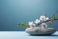 Simple stone and flowers scene on a light blue backdrop