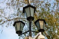 Simple street lights under the open sky. Black metal frame and dusty white glass