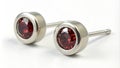 Simple stud earrings made from melted titanium scraps featuring smooth polished labgrown garnets that catch the light.. Royalty Free Stock Photo
