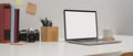 Simple study table with mock up laptop, pencil, notepad, camera, books, cup and copy space on white table Royalty Free Stock Photo