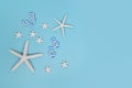 Simple summer banner with white starfish and sandals on blue background