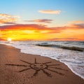 Simple sun drawing in the sand on sunset beach Royalty Free Stock Photo