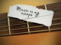 Simple text message on a small piece of ripped paper - music is my escape. With guitar background.