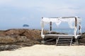 Simple timber beach shack with white shade on the rock beach