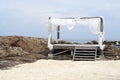 Simple timber beach shack with white shade on the rock beach