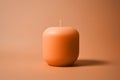 A simple unlit peach fuzz color candle on minimal background