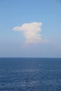 simple vertical background with blue sea below and a tall white cloud in the sky
