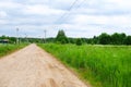 Simple village dirt road in Russia. Rustic landscape. The road in the village. Wooden houses. Rural landscape. Summer in Royalty Free Stock Photo