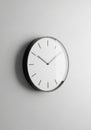 Simple wall clock with a minimalistic design, featuring a white face and black hour Royalty Free Stock Photo