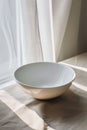 A simple white bowl placed on a table. Suitable for various food and kitchen-related concepts Royalty Free Stock Photo