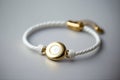 a simple white bracelet with a gold charm on it