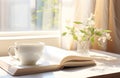 simple white breakfast cup with open book, book and white saucer,