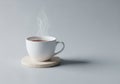 A simple white ceramic cup filled with steaming hot liquid sits on Royalty Free Stock Photo