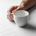 A simple white ceramic cup with a handle resting on a flat smooth Royalty Free Stock Photo