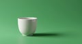 A simple white ceramic cup is placed on a green surface with a matching green Royalty Free Stock Photo