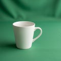 A simple white ceramic mug with a curved handle is placed on a Royalty Free Stock Photo