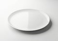 A simple white ceramic plate casting a soft shadow on a clean white surface Royalty Free Stock Photo