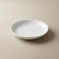 A simple white ceramic plate rests on a beige textured fabric surface. The plate is Royalty Free Stock Photo