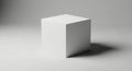 Simple white cube casting a distinct shadow on a neutral gray studio surface Royalty Free Stock Photo