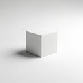 A simple white cube rests on a smooth, light gray background Royalty Free Stock Photo