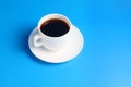 Simple white cup with black coffee on a saucer