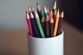 A simple white cup containing coloured pencils Royalty Free Stock Photo