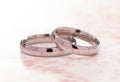 Simple White Gold Wedding Rings on a Pink Table