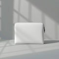 A simple white laptop sleeve with a zipper on a white surface with shadow patterns on the wall Royalty Free Stock Photo
