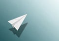 White paper airplane flying with shadow on blue background Royalty Free Stock Photo