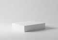 A simple white rectangular box is centrally placed on an equally white surface. The Royalty Free Stock Photo