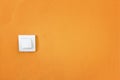 simple white switch on bright orange wall Royalty Free Stock Photo