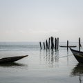 Simple wooden boats moored at timber logs at harbor of Bubaque island, Bijagos Archipelago, Guinea Bissau Royalty Free Stock Photo