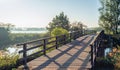 Simple wooden bridge with planks over a narrow Dutch river in th Royalty Free Stock Photo