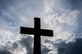 Simple wooden catholic cross silhouette, dramatic storm clouds