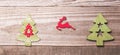 Simple wooden Christmas trees and red flying reindeer on a gree