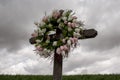 Simple Wooden Cross with a Wreath of White and Pink Silk Tulips