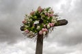 Simple Wooden Cross with a Wreath of White and Pink Silk Tulips