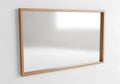 Simple wooden framed mirror reflecting a bright light source on a white wall Royalty Free Stock Photo
