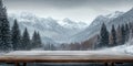 A simple wooden table covered with a light dusting of snow, with towering mountains in the Royalty Free Stock Photo