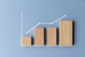 Simple wooden toy block financial bar chart graph with upward trend line on blue color background Royalty Free Stock Photo