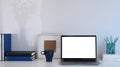 Simple workplace with computer laptop, coffee cup, books and stationery on white desk. Royalty Free Stock Photo