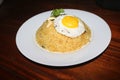 Simple yellow rice plate with egg yolk, plums, mint leaf,lemon slice on white plate on wood table Royalty Free Stock Photo