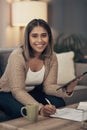 The simplest way to get your bills paid. a young woman using a digital tablet while going through paperwork at home. Royalty Free Stock Photo