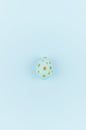 Simplicity and minimal design of easter egg with gold dots on blue background, top view.