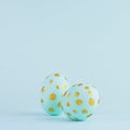 Simplicity and minimal design of easter eggs with gold dots on blue background, square.