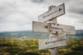 simplicity patience compassion text engraved on old wooden signpost outdoors in nature