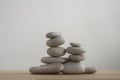 Simplicity stones cairns isolated on white background, group of light gray pebbles built in towers, wood table Royalty Free Stock Photo